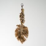 Porte-clés artisanal en coquillages et feuille tressée